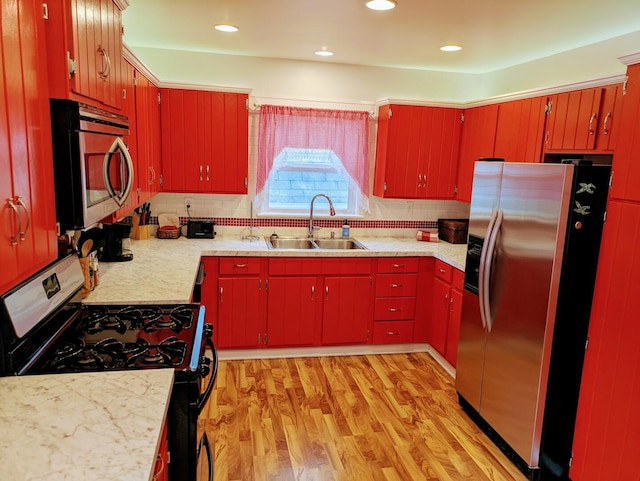 100 Watson Ave, Oglesby, IL 61348 - kitchen with appliances with stainless steel finishes, a sink, red cabinets, light countertops, and light wood finished floors
