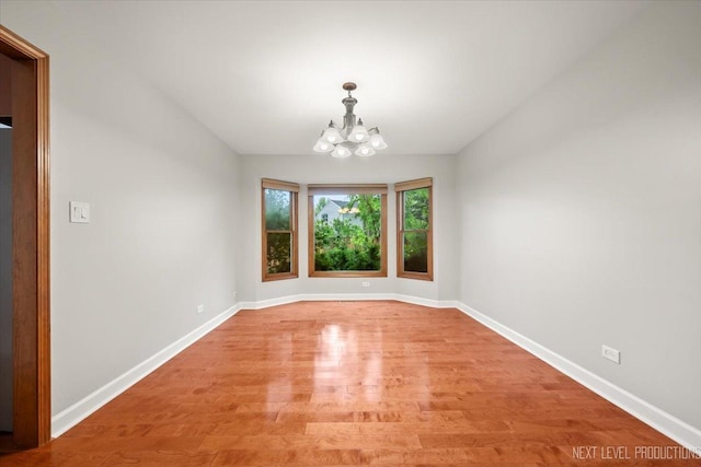 2556 Leach Dr, Naperville, IL 60564 - unfurnished room with a chandelier, light wood finished floors, and baseboards