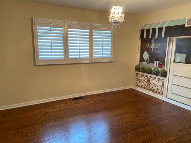 473 S Edgewood Ave, Wood Dale, IL 60191 - unfurnished dining area featuring a chandelier, dark wood-style flooring, and baseboards