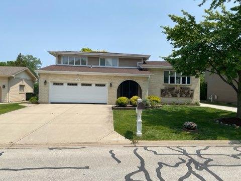 473 S Edgewood Ave, Wood Dale, IL 60191 - tri-level home featuring concrete driveway, a front yard, an attached garage, and brick siding