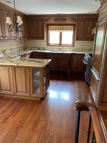 473 S Edgewood Ave, Wood Dale, IL 60191 - kitchen featuring high end stove, a sink, light stone counters, brown cabinets, and glass insert cabinets