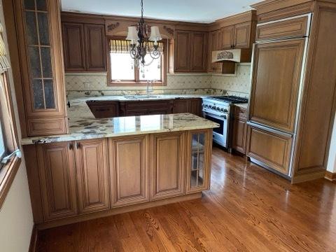 473 S Edgewood Ave, Wood Dale, IL 60191 - kitchen with high quality appliances, a sink, wood finished floors, a chandelier, and tasteful backsplash
