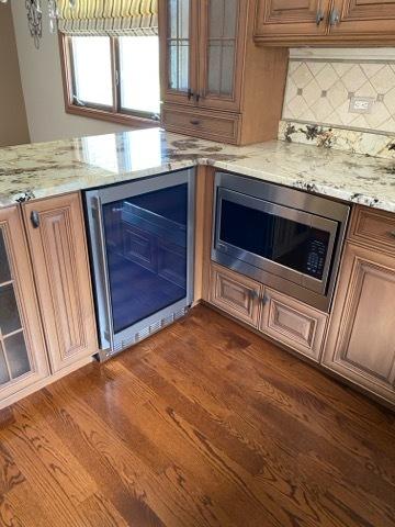473 S Edgewood Ave, Wood Dale, IL 60191 - kitchen view of wine cooler, stainless steel microwave, decorative backsplash, and light stone counters