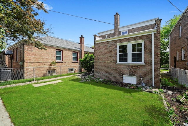 9012 S Harper Ave, Chicago, IL 60619 - rear view of property with brick siding, central air condition unit, and a chimney