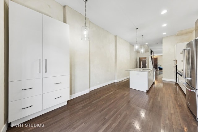 3342 S Giles Ave, Chicago, IL 60616 - kitchen with freestanding refrigerator, dark wood finished floors, a kitchen island with sink, light countertops, and decorative light fixtures