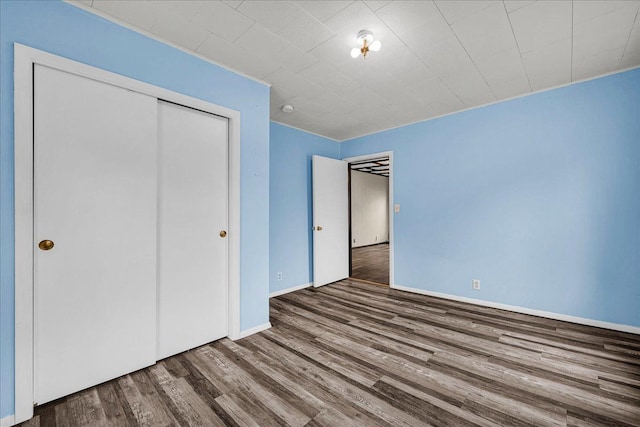 913 N Mason St, Bloomington, IL 61701 - unfurnished bedroom featuring wood finished floors, a closet, and baseboards