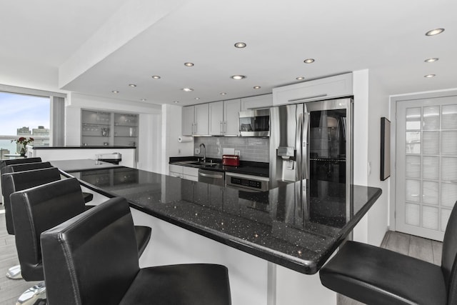 1255 N Sandburg Ter Unit 2912, Chicago, IL 60610 - kitchen featuring appliances with stainless steel finishes, a sink, recessed lighting, tasteful backsplash, and a breakfast bar area