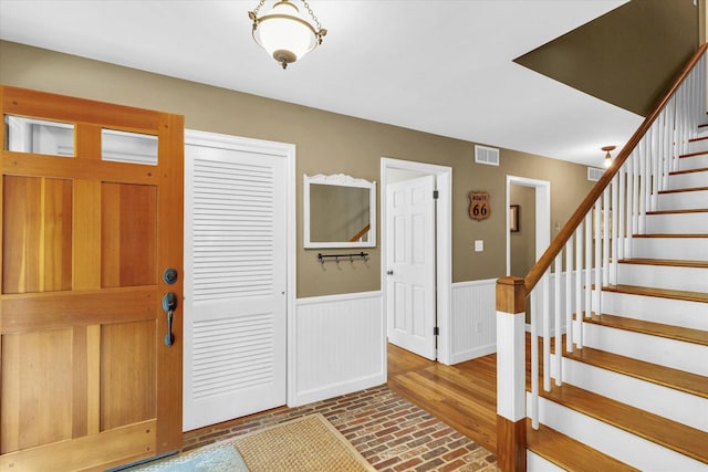 2804 E Concord Rd, Urbana, IL 61802 - entryway featuring brick patterned floors, stairs, and a wainscoted wall