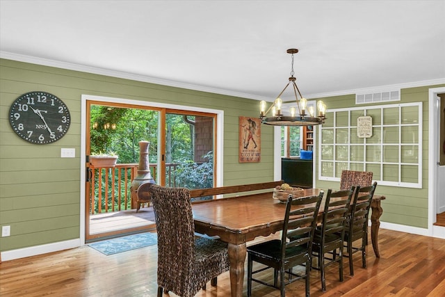 2804 E Concord Rd, Urbana, IL 61802 - dining area featuring wood finished floors, a chandelier, ornamental molding, and wooden walls