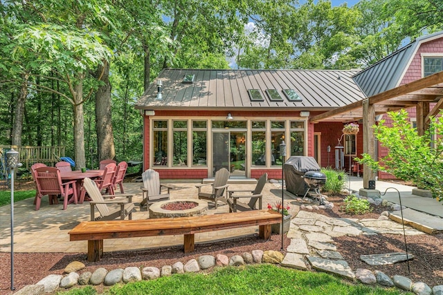 2804 E Concord Rd, Urbana, IL 61802 - rear view of property with a standing seam roof, an outdoor fire pit, a patio, a metal roof, and outdoor dining area
