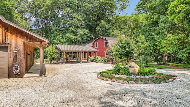2804 E Concord Rd, Urbana, IL 61802 - view of front facade featuring a gambrel roof, gravel driveway, a chimney, and a metal roof