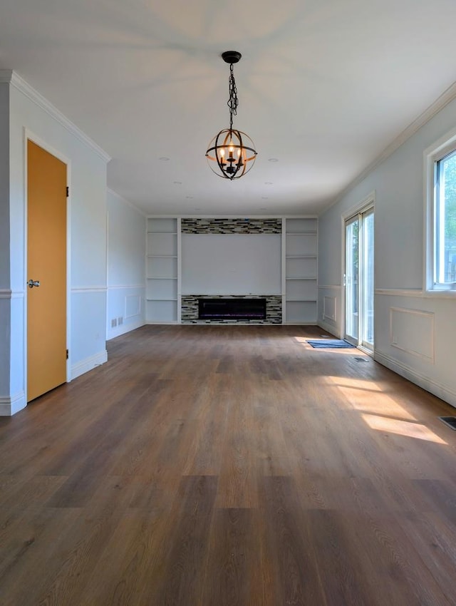 235 E Manchester Dr, Wheeling, IL 60090 - unfurnished living room featuring built in features, crown molding, a chandelier, wood finished floors, and a decorative wall