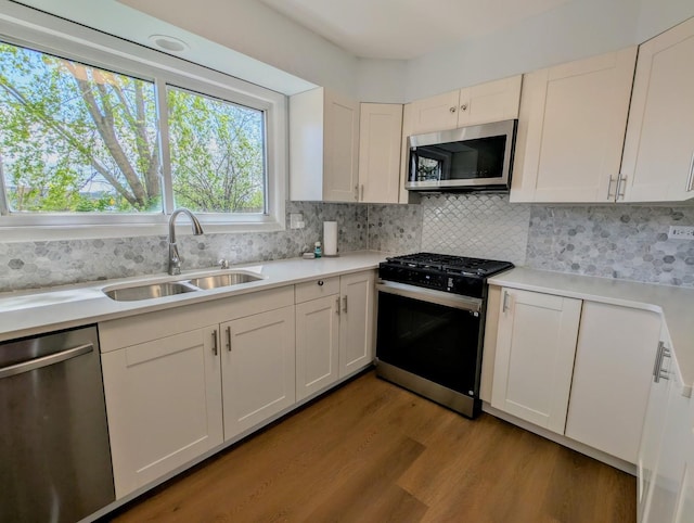 235 E Manchester Dr, Wheeling, IL 60090 - kitchen featuring appliances with stainless steel finishes, wood finished floors, light countertops, decorative backsplash, and white cabinets