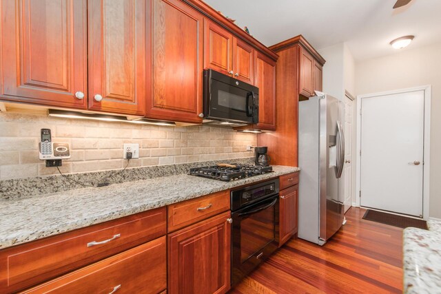9215 Waterfall Glen Blvd, Darien, IL 60561 - kitchen with black appliances, dark wood-style floors, light stone counters, tasteful backsplash, and brown cabinetry