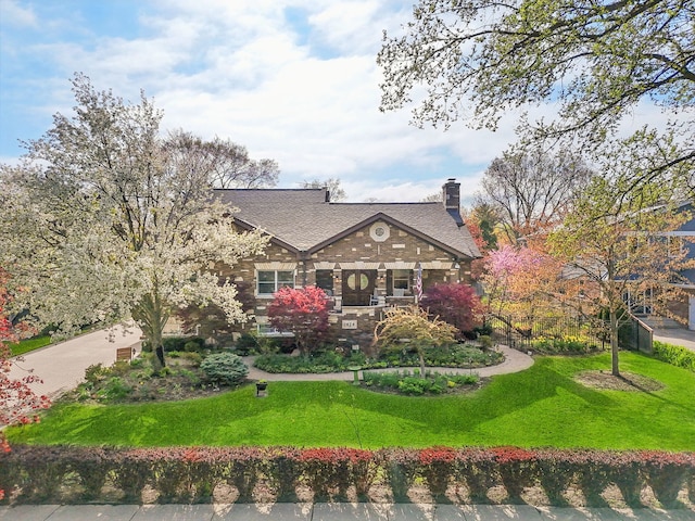 1424 Glencoe Ave, Highland Park, IL 60035 - tudor home with a front yard, a chimney, and roof with shingles