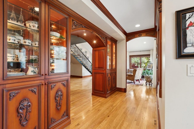 1424 Glencoe Ave, Highland Park, IL 60035 - hallway featuring light wood finished floors, baseboards, stairs, arched walkways, and ornamental molding