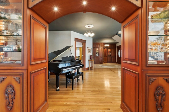 1424 Glencoe Ave, Highland Park, IL 60035 - hallway featuring light wood finished floors, a chandelier, arched walkways, baseboards, and lofted ceiling