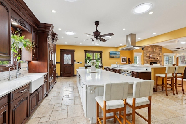 1424 Glencoe Ave, Highland Park, IL 60035 - kitchen with island range hood, a ceiling fan, stone tile floors, a sink, and a spacious island