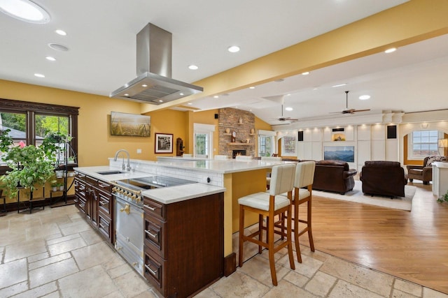 1424 Glencoe Ave, Highland Park, IL 60035 - kitchen with island exhaust hood, stone tile floors, a sink, a large island with sink, and dark brown cabinets