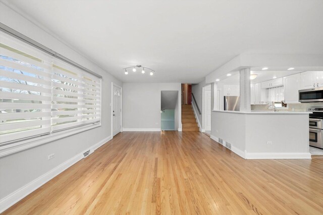 7011 Avon Ave, Oak Lawn, IL 60453 - unfurnished living room featuring light wood-type flooring, stairs, baseboards, and recessed lighting