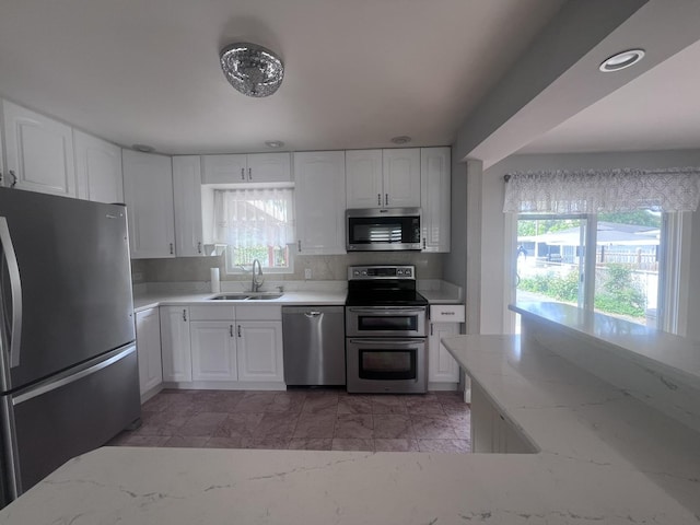7011 Avon Ave, Oak Lawn, IL 60453 - kitchen featuring appliances with stainless steel finishes, a sink, healthy amount of natural light, and light stone counters