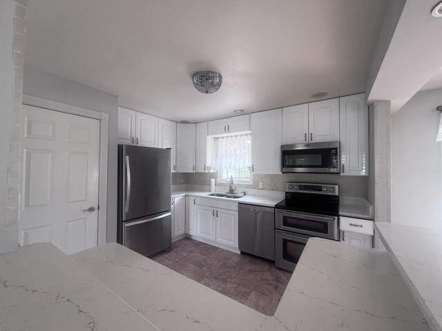 7011 Avon Ave, Oak Lawn, IL 60453 - kitchen with appliances with stainless steel finishes, a sink, light stone counters, and white cabinets