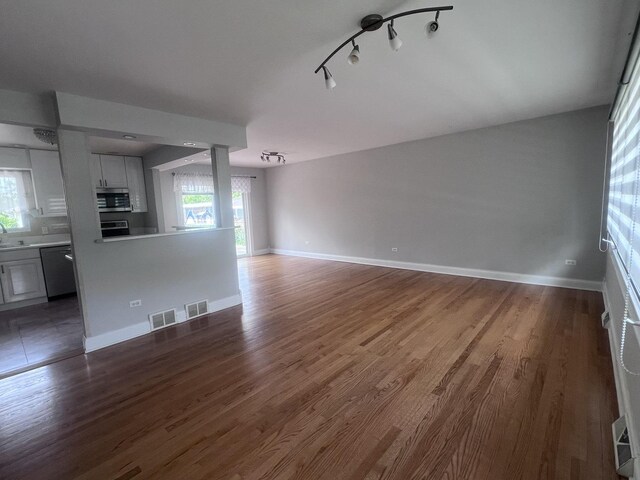 7011 Avon Ave, Oak Lawn, IL 60453 - unfurnished living room with healthy amount of natural light, dark wood finished floors, and baseboards