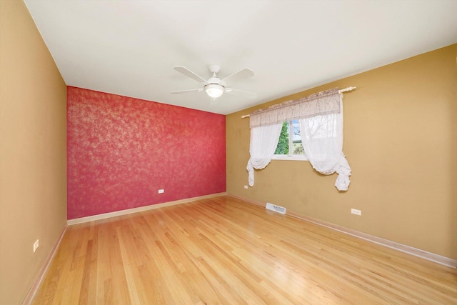 7011 Avon Ave, Oak Lawn, IL 60453 - empty room featuring an accent wall, light wood finished floors, baseboards, ceiling fan, and wallpapered walls