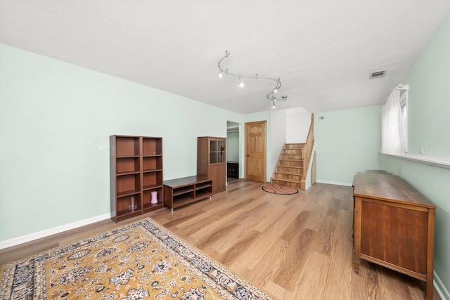 7011 Avon Ave, Oak Lawn, IL 60453 - living area featuring light wood-style flooring, stairs, baseboards, and a textured ceiling