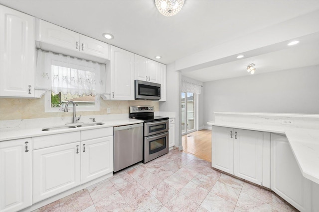 7011 Avon Ave, Oak Lawn, IL 60453 - kitchen featuring appliances with stainless steel finishes, a sink, white cabinets, recessed lighting, and light marble finish flooring