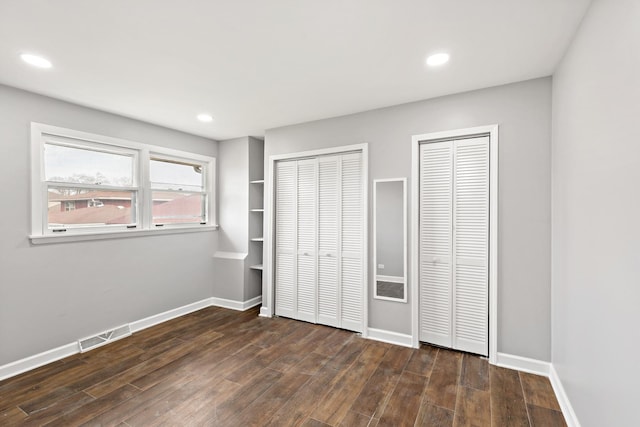 20054 Terrace Ave, Lynwood, IL 60411 - unfurnished bedroom with multiple closets, dark wood-type flooring, baseboards, and recessed lighting