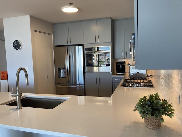 1515 S Prairie Ave Unit 1016, Chicago, IL 60605 - kitchen featuring stainless steel appliances, a sink, gray cabinets, light countertops, and tasteful backsplash