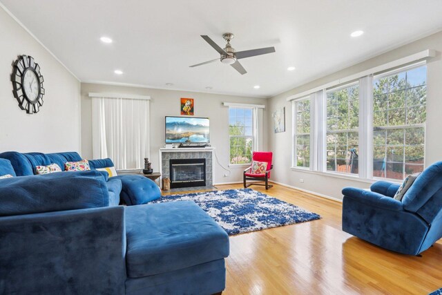 263 Thrush Cir, Lindenhurst, IL 60046 - living area featuring wood finished floors, a ceiling fan, a tiled fireplace, baseboards, and recessed lighting