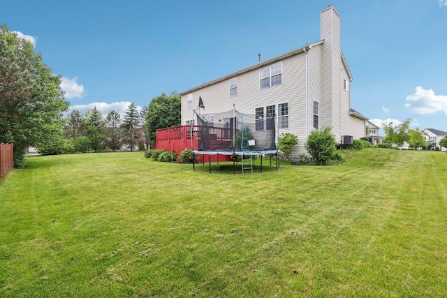 263 Thrush Cir, Lindenhurst, IL 60046 - rear view of house with a trampoline, a yard, a chimney, and central AC