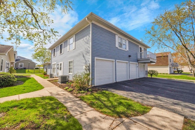 1330 Woodcutter Ln, Wheaton, IL 60189 - view of property exterior with a garage, asphalt driveway, central AC, and a lawn
