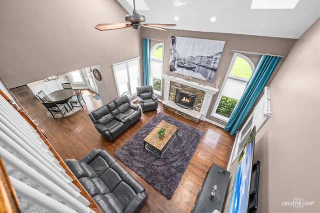 2417 Wentworth Ln, Aurora, IL 60502 - living room with ceiling fan, a stone fireplace, a high ceiling, wood finished floors, and recessed lighting