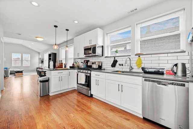 3238 N Whipple St, Chicago, IL 60618 - kitchen with stainless steel appliances, a sink, a peninsula, dark countertops, and decorative backsplash
