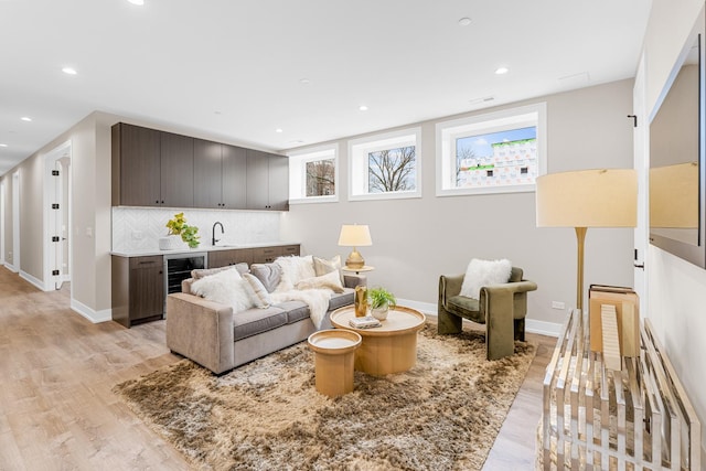1636 W Wolfram St, Chicago, IL 60657 - living room featuring light wood-style floors, baseboards, recessed lighting, bar with sink, and beverage cooler