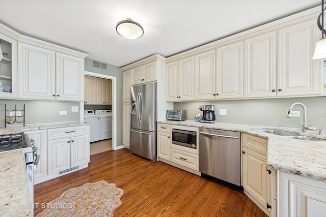 13922 Steepleview Ln, Lemont, IL 60439 - kitchen featuring stainless steel appliances, separate washer and dryer, light wood-style flooring, glass insert cabinets, and light stone countertops