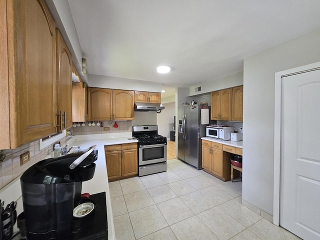 4400 Waubansie Ln, Lisle, IL 60532 - kitchen featuring appliances with stainless steel finishes, under cabinet range hood, brown cabinetry, light countertops, and backsplash