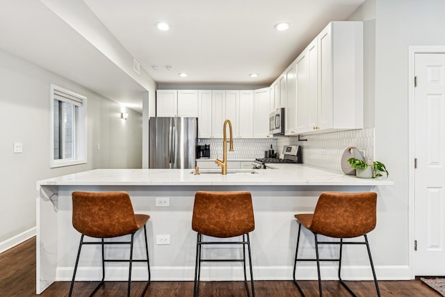 2309 W Chicago Ave Unit 1, Chicago, IL 60622 - kitchen with appliances with stainless steel finishes, a sink, a peninsula, white cabinetry, and recessed lighting