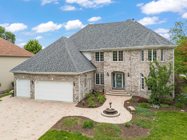 499 Waubonsee Cir, Oswego, IL 60543 - view of front facade featuring roof with shingles, a garage, and decorative driveway