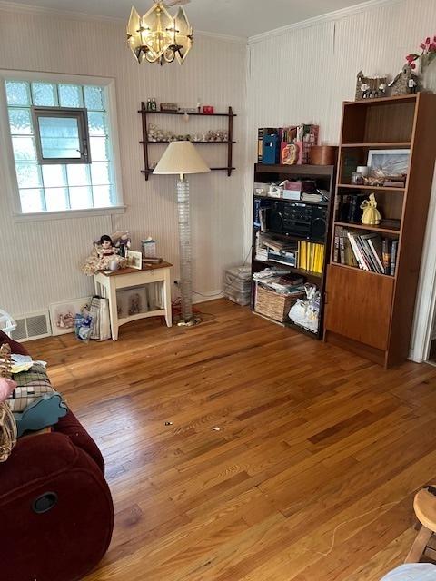 2130 N 74th Ct, Elmwood Park, IL 60707 - dining area with ornamental molding, a chandelier, and wood finished floors