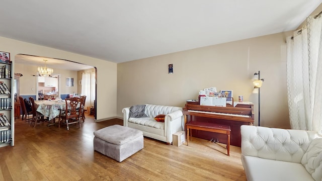 6522 N Sacramento Ave, Chicago, IL 60645 - living area featuring arched walkways, light wood-style floors, and a chandelier