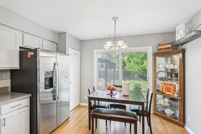 4801 Bordeaux Dr, Lake In The Hills, IL 60156 - kitchen featuring stainless steel fridge, a chandelier, light wood-type flooring, and white cabinetry