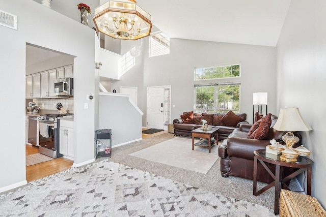 4801 Bordeaux Dr, Lake In The Hills, IL 60156 - living room featuring high vaulted ceiling, stairs, a chandelier, baseboards, and light colored carpet