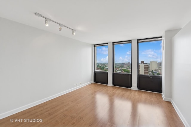444 W Fullerton Pkwy Unit 1702, Chicago, IL 60614 - unfurnished room with wood finished floors and rail lighting