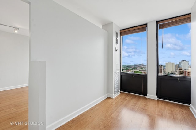 444 W Fullerton Pkwy Unit 1702, Chicago, IL 60614 - unfurnished room with light wood-style floors, a view of city, and rail lighting