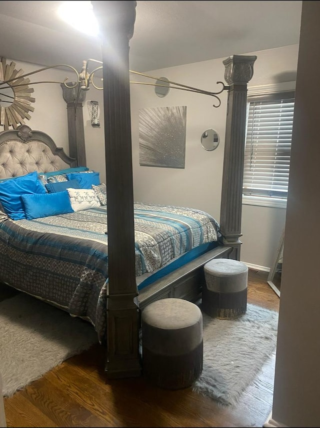 bedroom with wood finished floors and a chandelier