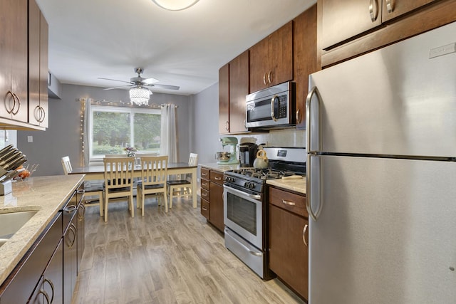 2642 N Windsor Dr Unit 102, Arlington Heights, IL 60004 - kitchen featuring appliances with stainless steel finishes, light wood-style flooring, ceiling fan, and light stone countertops